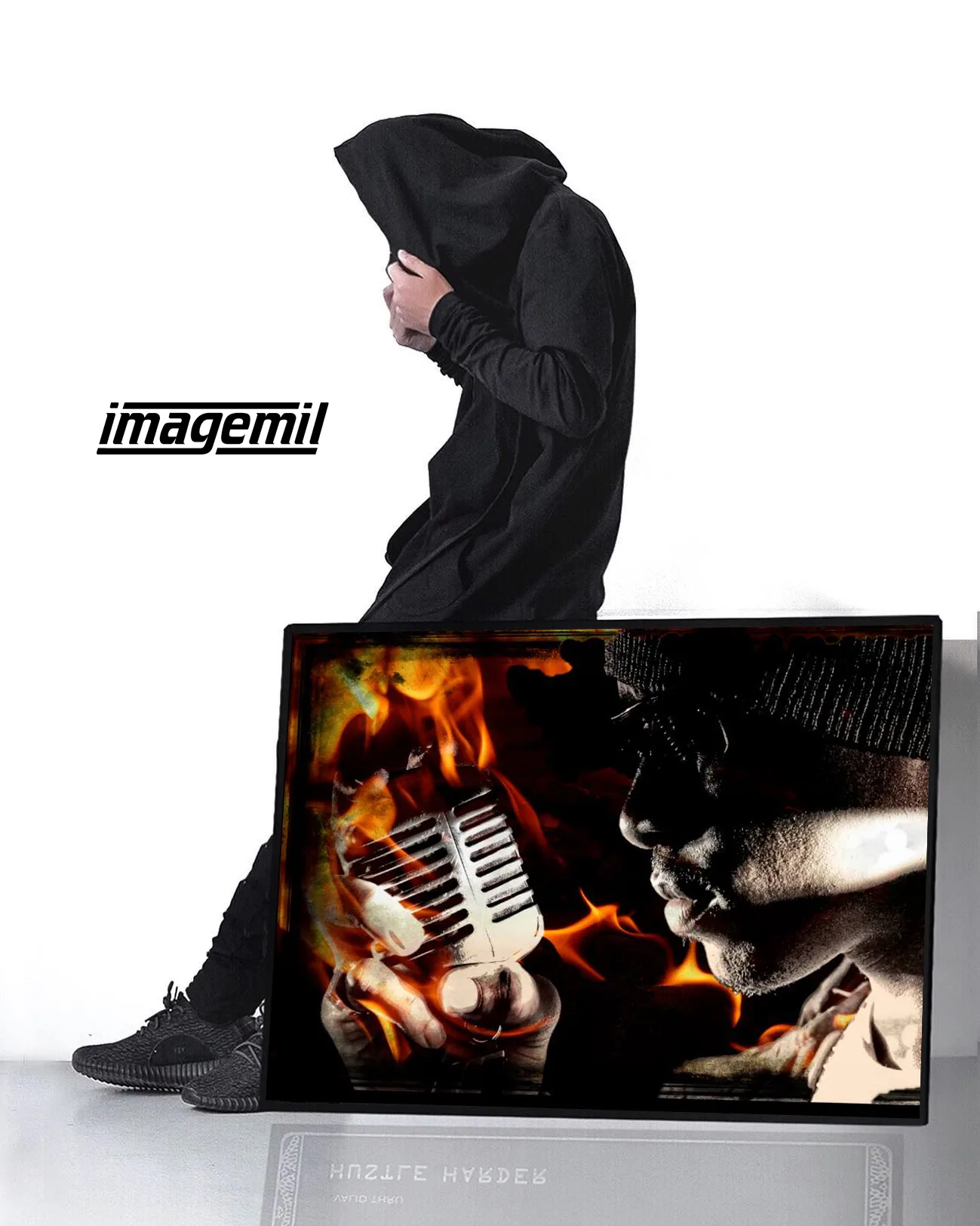 A hooded figure holding a printed frame of a singer and flames