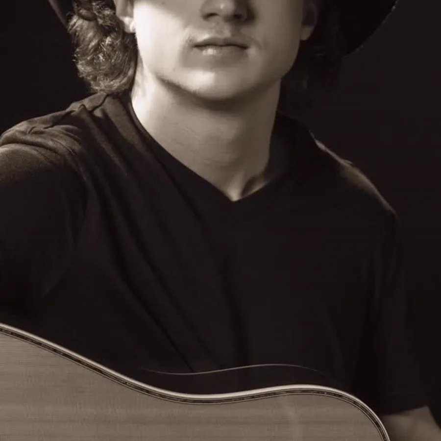 Black-and-white portrait of a musician holding a guitar